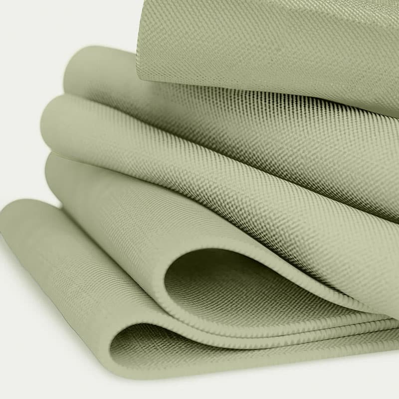 Folded sage green textured fabric showcasing soft, durable woven material ideal for upholstery, home décor, or sustainable textiles.