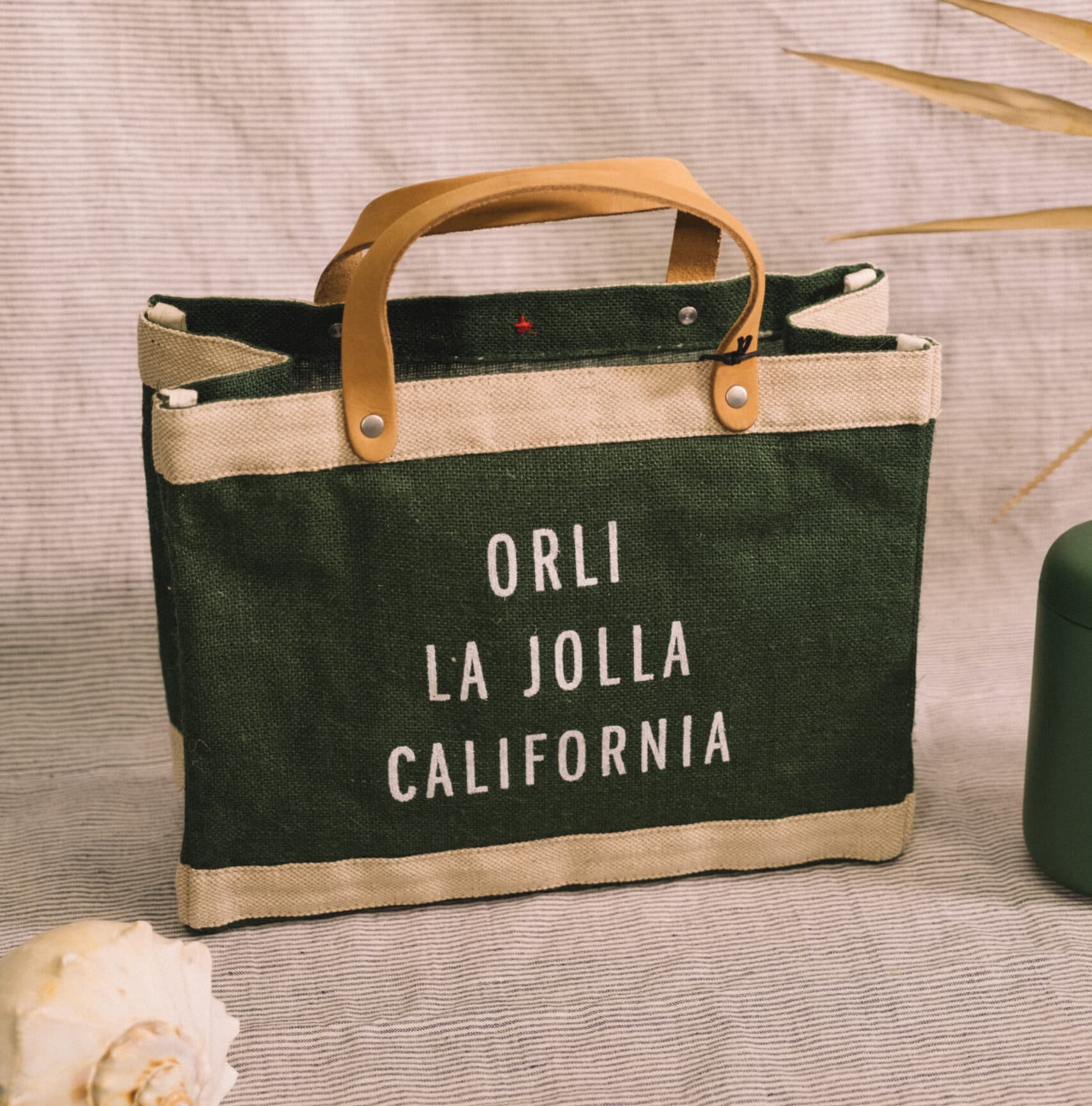 Orli La Jolla California canvas tote bag with leather handles displayed on a neutral textured background