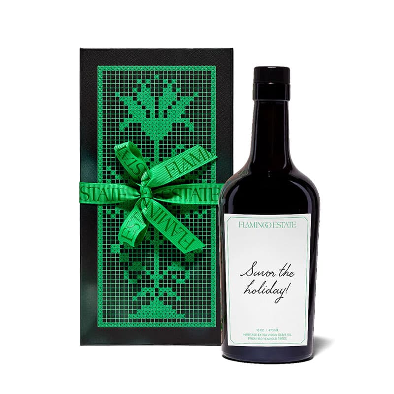 Holiday gift bottle with festive green ribbon and decorative box, featuring a premium seasonal beverage presented for elegant gifting.